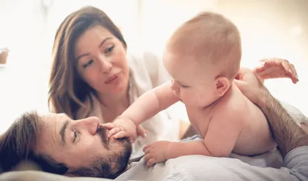 Un bébé dans les bras de ses parents