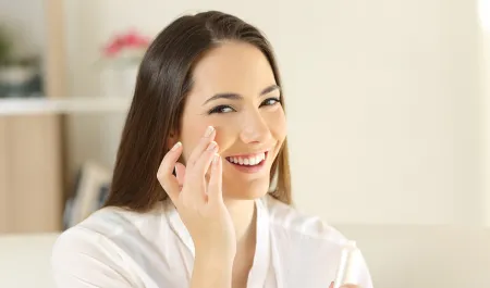 Une femme hydrate sa peau sèche